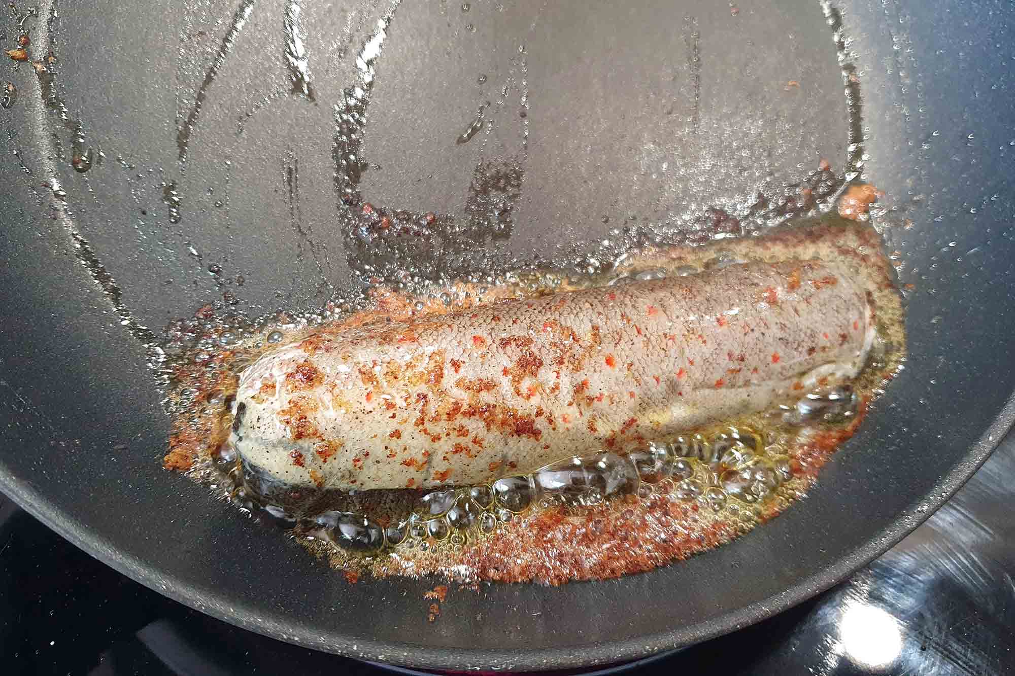 Forelle beim Anbraten Forelle wird in einer Pfanne angebraten